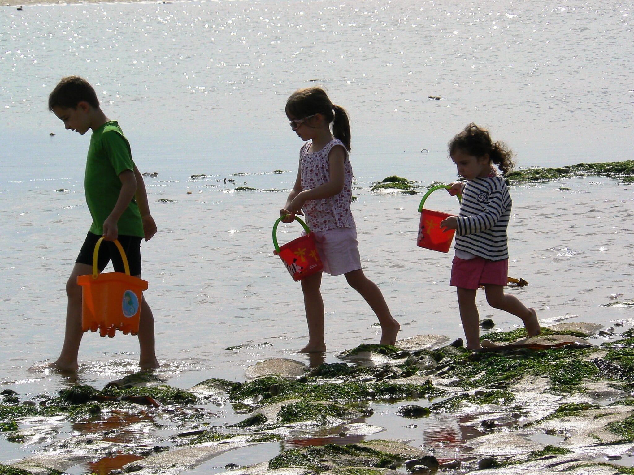 Trois enfants marchent sur la plage