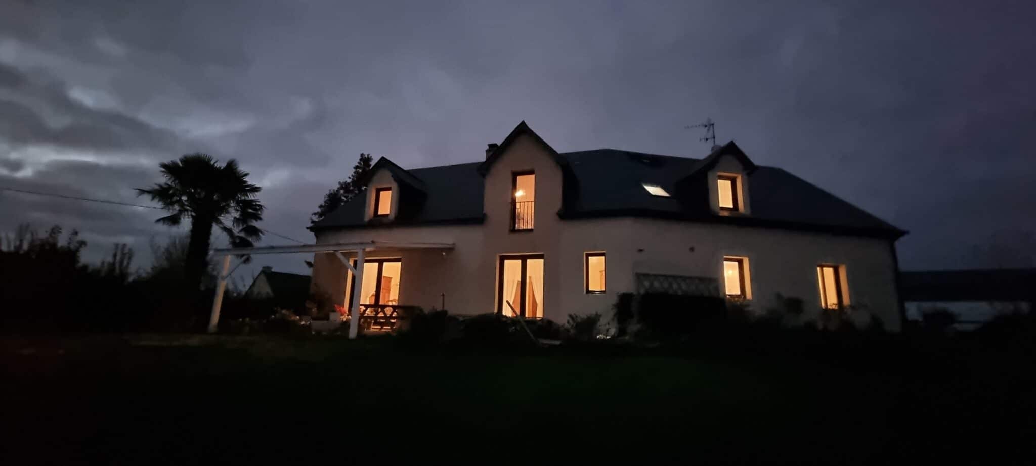 Vent immobilière maison éclairée à la tombée de la nuit